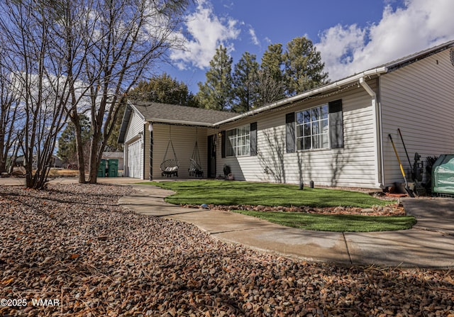 ranch-style home featuring a garage and a front yard