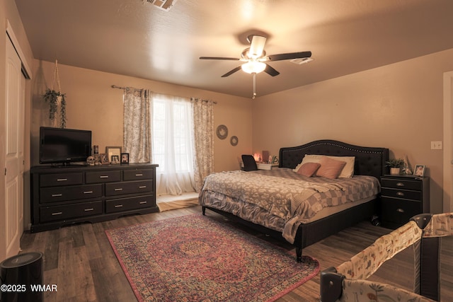 bedroom featuring dark wood-type flooring, ceiling fan, and a closet