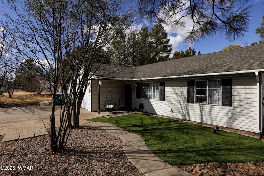 ranch-style home with a front lawn and a shingled roof