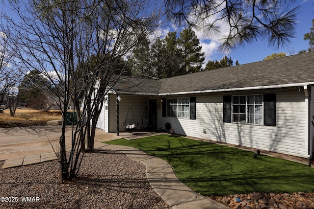 ranch-style home with a front lawn and a shingled roof