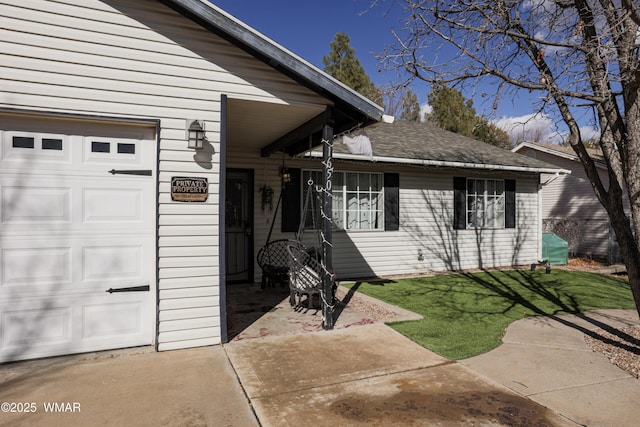 doorway to property featuring a garage, a lawn, and roof with shingles