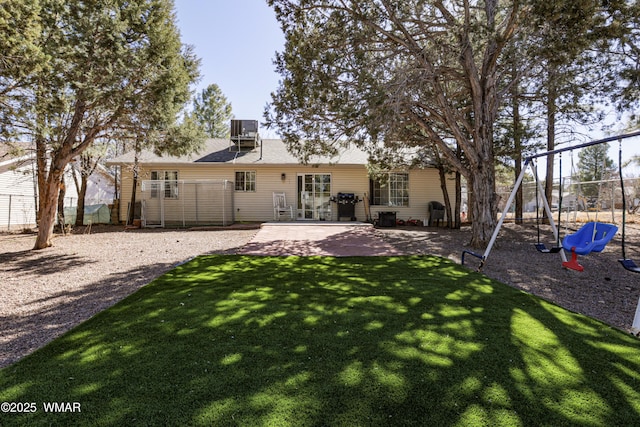 rear view of house with a playground, central AC unit, and a patio area
