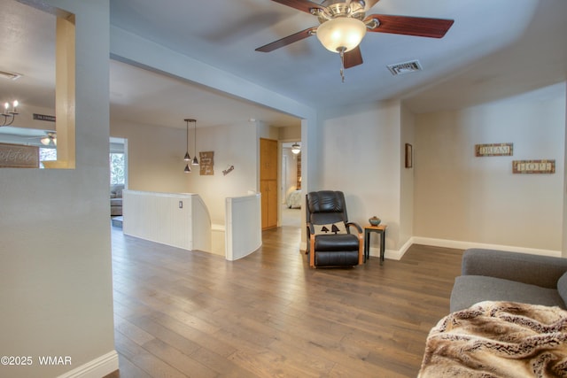 living room featuring baseboards, hardwood / wood-style flooring, visible vents, and ceiling fan