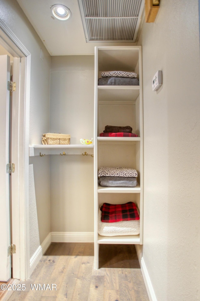 walk in closet featuring wood finished floors and visible vents