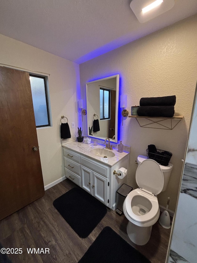 bathroom featuring toilet, wood finished floors, and vanity