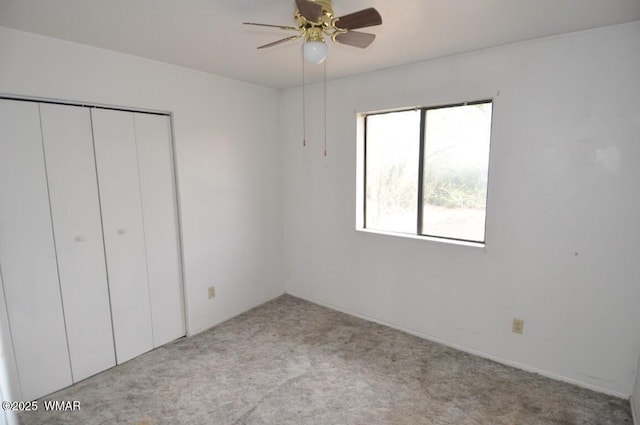 unfurnished bedroom with a closet, carpet floors, and a ceiling fan