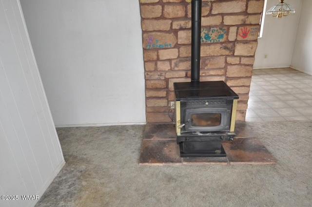detailed view of carpet floors, a wood stove, and baseboards