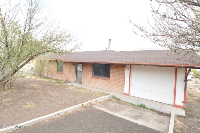 ranch-style house with brick siding, a shingled roof, and uncovered parking