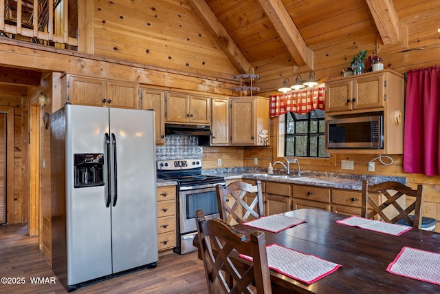 kitchen with wooden walls, appliances with stainless steel finishes, dark countertops, and under cabinet range hood