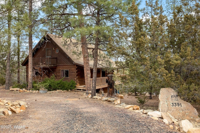 view of side of property featuring a wooden deck and log siding