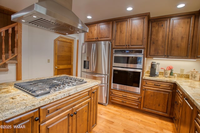 2761 Blue Lupine Ln, Pinetop, AZ 85935 - kitchen with light wood-style flooring, light stone countertops, stainless steel appliances, and range hood
