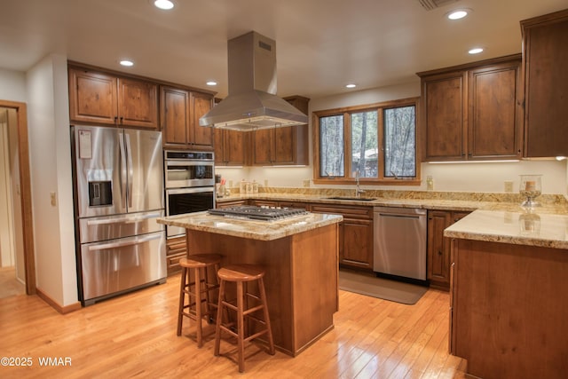 2761 Blue Lupine Ln, Pinetop, AZ 85935 - kitchen featuring island range hood, a sink, light wood-style flooring, light stone countertops, and appliances with stainless steel finishes