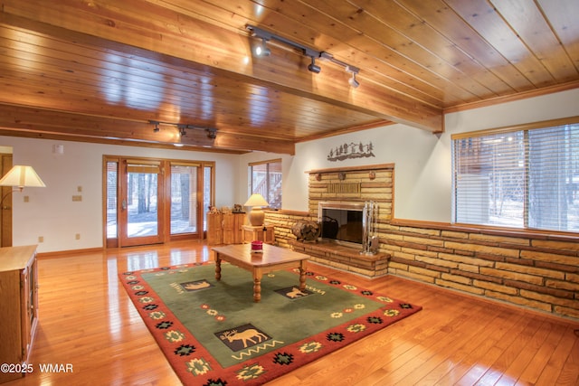 2761 Blue Lupine Ln, Pinetop, AZ 85935 - living room featuring light wood-style flooring, beamed ceiling, a fireplace, brick wall, and wooden ceiling