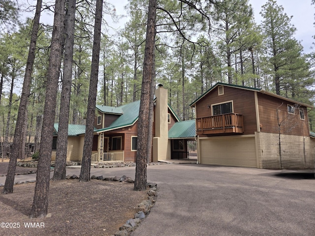 2761 Blue Lupine Ln, Pinetop, AZ 85935 - chalet / cabin featuring a chimney, metal roof, aphalt driveway, and an attached garage