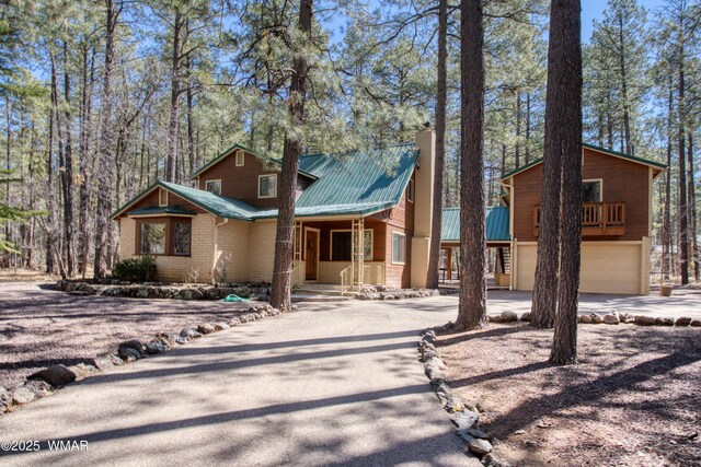 2761 Blue Lupine Ln, Pinetop, AZ 85935 - rustic home featuring metal roof, driveway, covered porch, a garage, and a chimney
