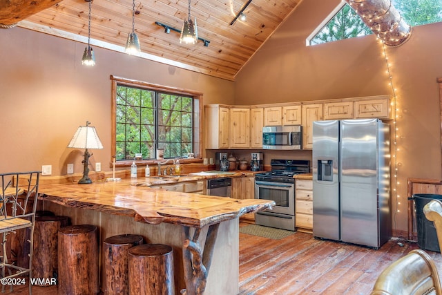 kitchen with high vaulted ceiling, wood ceiling, light wood-style flooring, a peninsula, and appliances with stainless steel finishes