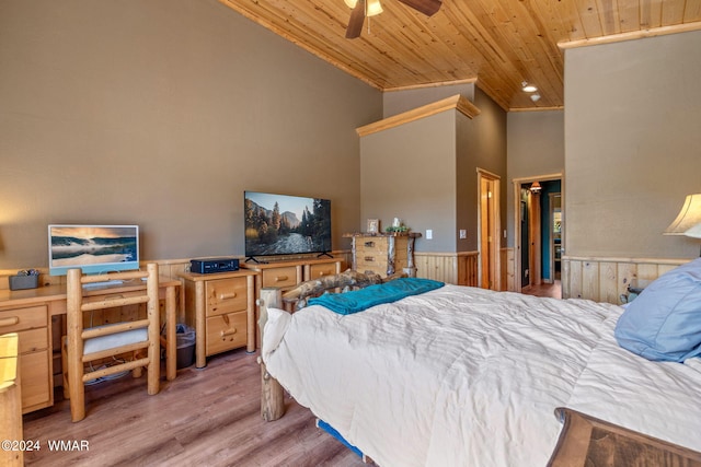 bedroom featuring high vaulted ceiling, wood finished floors, wainscoting, ceiling fan, and wooden ceiling