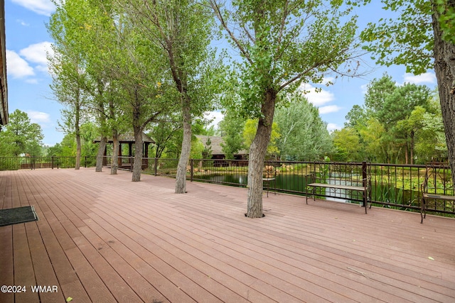 wooden terrace featuring a gazebo and a water view