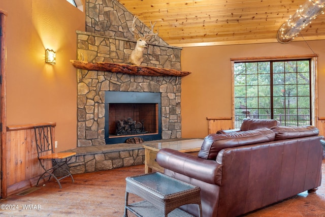 living area featuring vaulted ceiling, wood ceiling, and a stone fireplace
