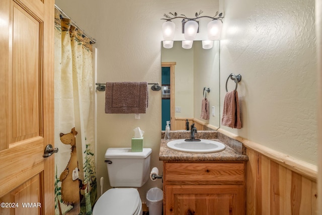 bathroom featuring wainscoting, toilet, a shower with curtain, and vanity