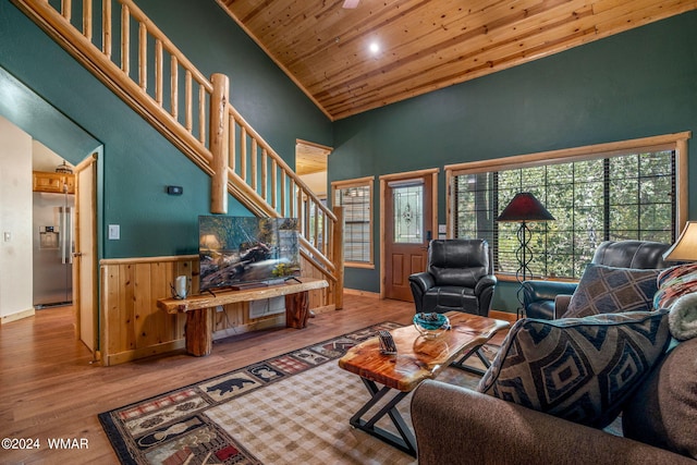 living area with stairway, high vaulted ceiling, wood finished floors, wainscoting, and wood ceiling