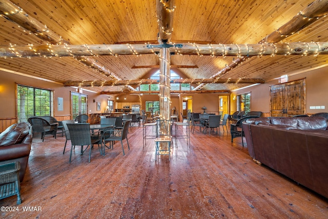 dining space featuring wainscoting, wood-type flooring, wooden ceiling, and beam ceiling