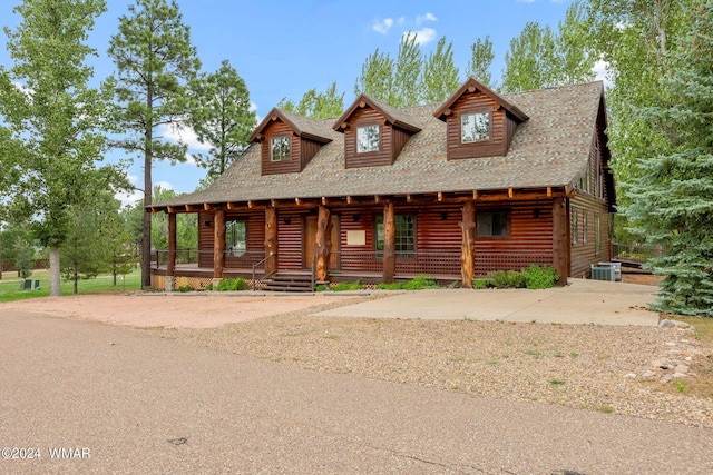log cabin featuring central AC unit, a shingled roof, log siding, and covered porch