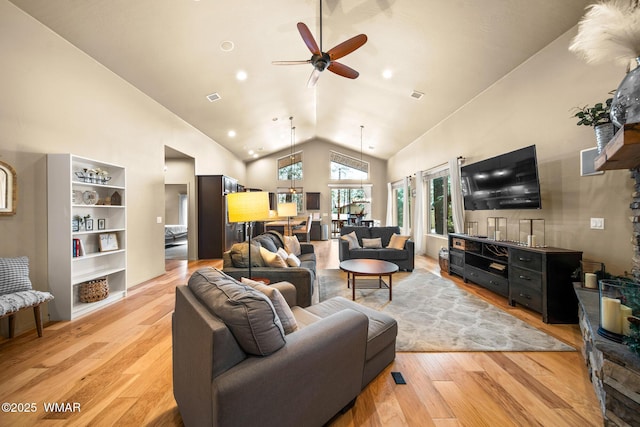living room featuring visible vents, high vaulted ceiling, light wood-style flooring, and a ceiling fan