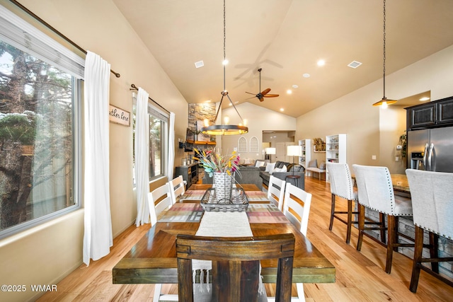 dining area featuring light wood-type flooring, a healthy amount of sunlight, a ceiling fan, and visible vents