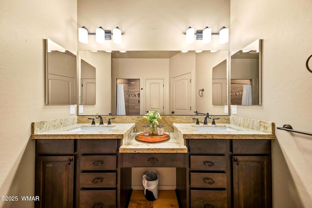 bathroom featuring double vanity, curtained shower, and a sink