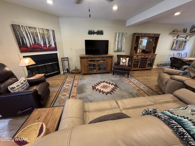 living room with ceiling fan, a glass covered fireplace, wood finished floors, and recessed lighting