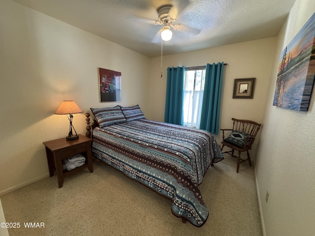 bedroom featuring a ceiling fan, carpet, baseboards, and a textured ceiling