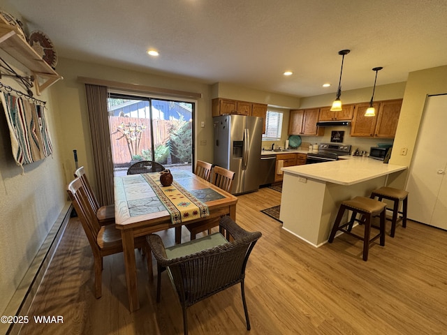 dining room featuring recessed lighting, baseboards, light wood-style flooring, and baseboard heating