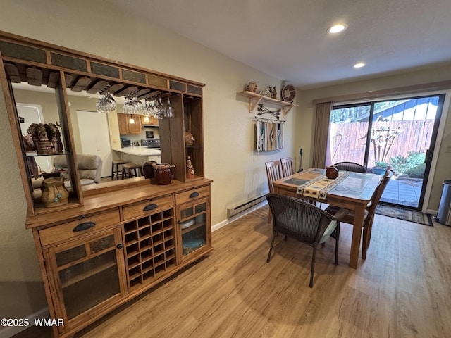 dining room featuring a baseboard radiator, baseboards, light wood-style flooring, and recessed lighting