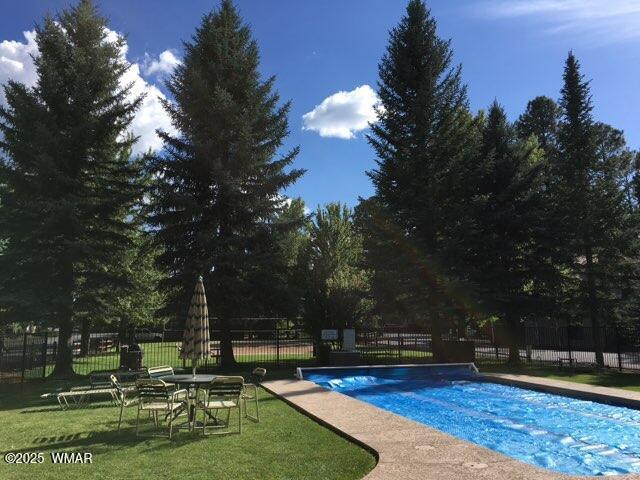 view of pool with fence, a fenced in pool, and a yard