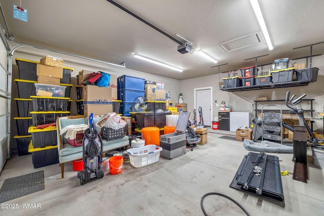 garage featuring fridge and a garage door opener