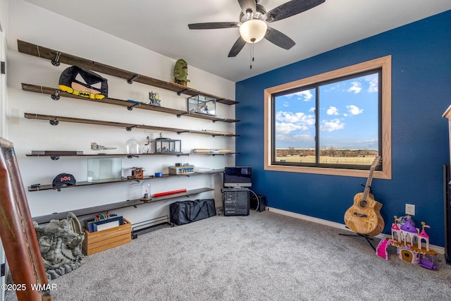 carpeted office space with ceiling fan and baseboards