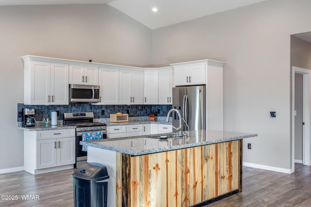 kitchen featuring an island with sink, appliances with stainless steel finishes, white cabinets, and a sink