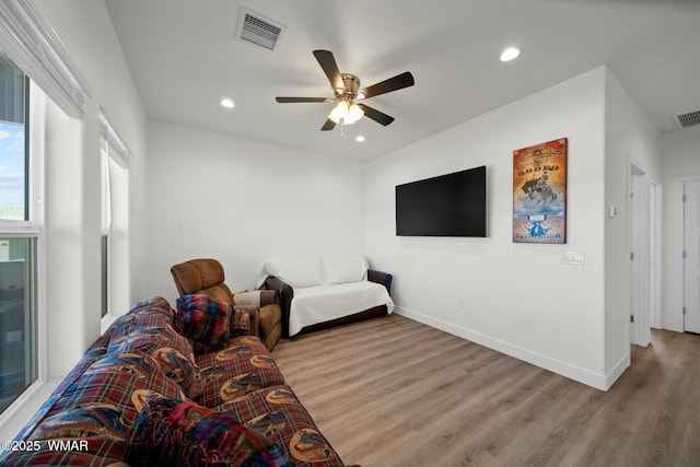 living room with wood finished floors, visible vents, and baseboards