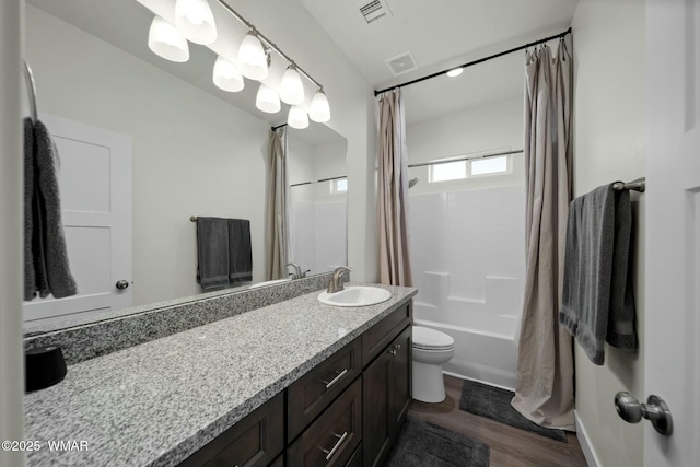 full bath with toilet, vanity, wood finished floors, and visible vents