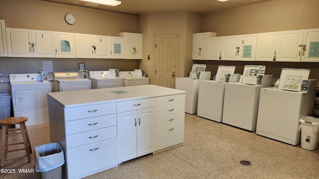 washroom featuring cabinet space and washer and clothes dryer