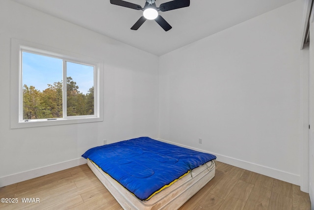 bedroom featuring light wood-style floors, baseboards, and ceiling fan