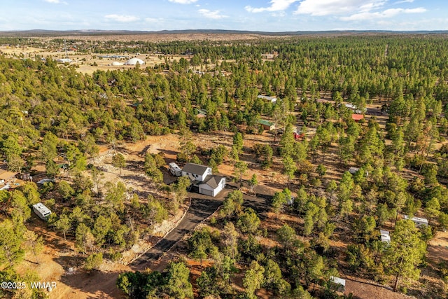 bird's eye view with a wooded view