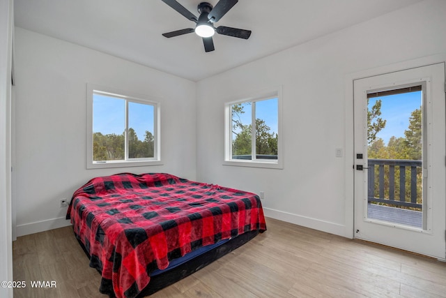 bedroom featuring baseboards, light wood-style flooring, ceiling fan, and access to outside