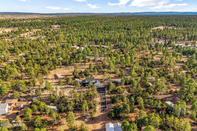 drone / aerial view with a wooded view