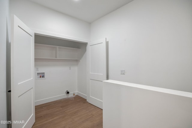 laundry area featuring baseboards, laundry area, washer hookup, and wood finished floors