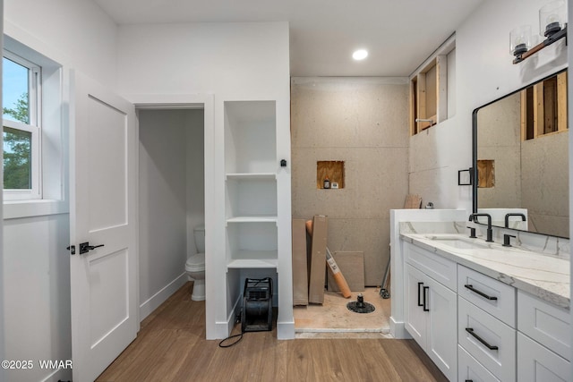 full bath with vanity, wood finished floors, toilet, recessed lighting, and a tile shower