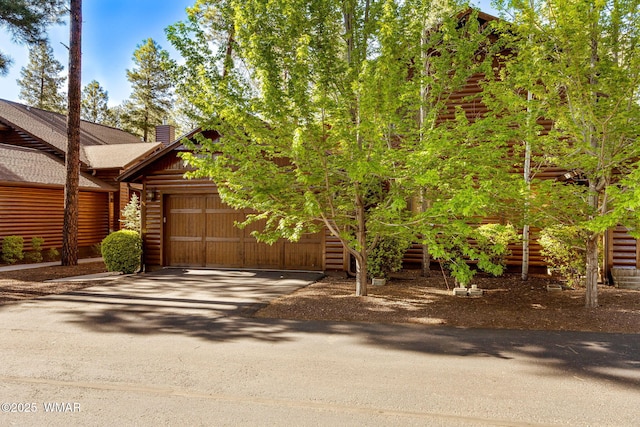 4186 Stone Pine Dr, Pinetop, AZ 85935 - log home with an attached garage, asphalt driveway, a chimney, roof with shingles, and log siding