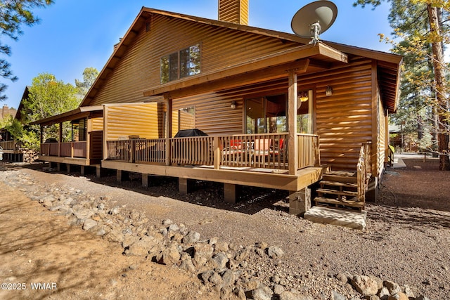 4186 Stone Pine Dr, Pinetop, AZ 85935 - view of front facade with a chimney, a wooden deck, and faux log siding