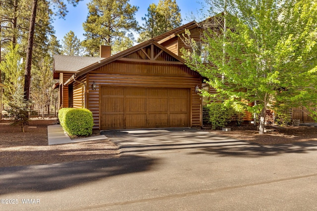4186 Stone Pine Dr, Pinetop, AZ 85935 - view of front facade with a chimney, an attached garage, and asphalt driveway